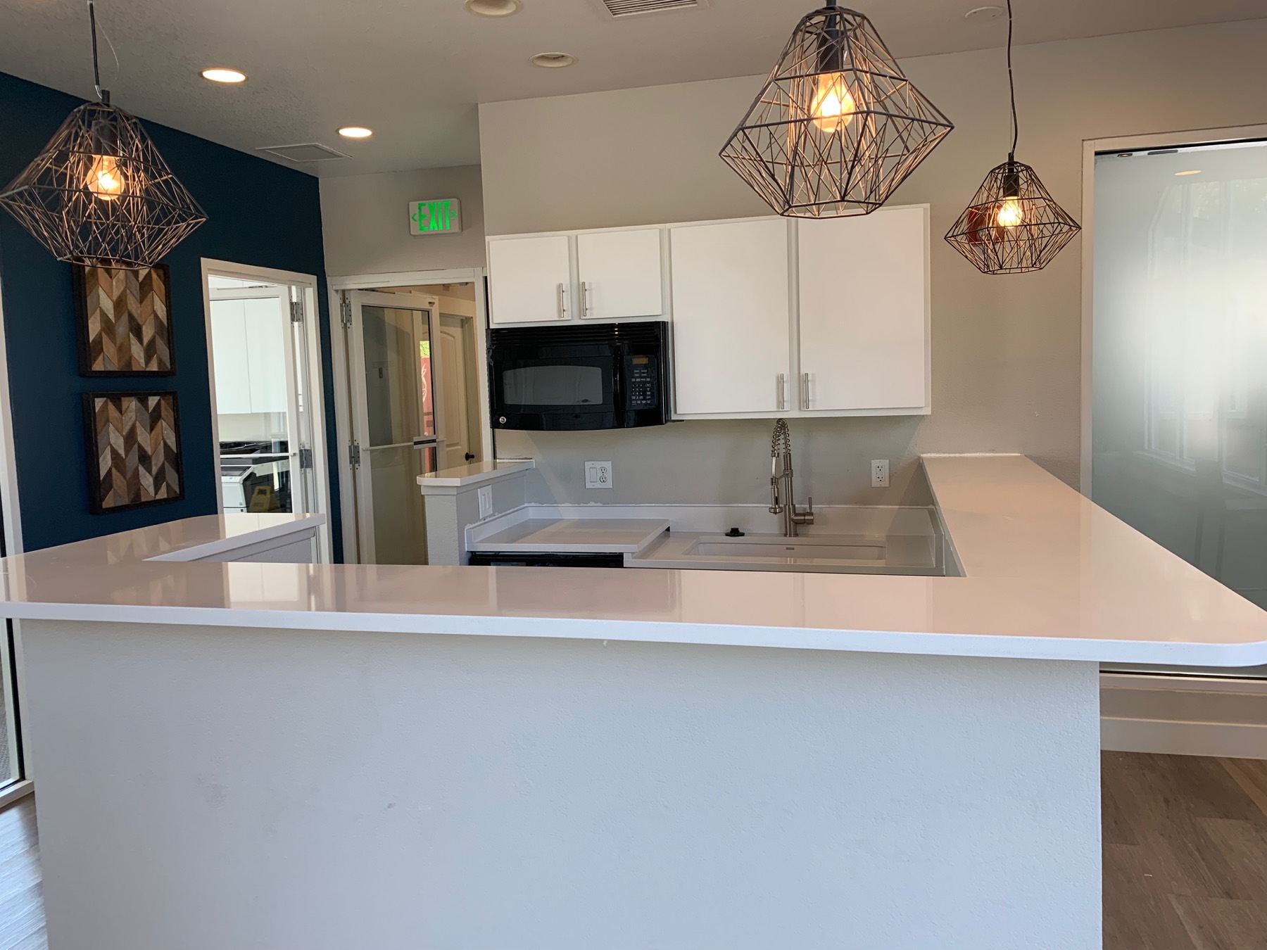 White kitchen renovation with blue accent wall and pendant lights